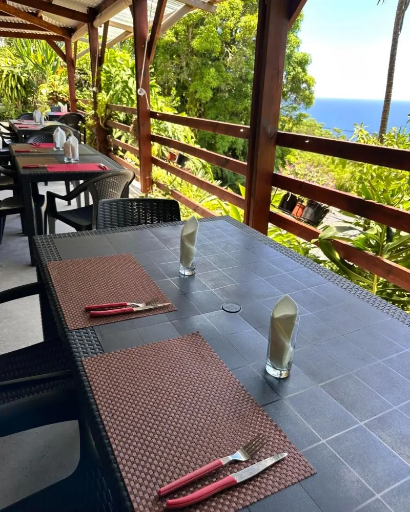 Une table de la terrasse, et l'océan au-delà de la balustrade en bois